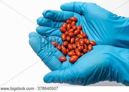 A Handful Of Red Lutein Tablets In The Hands Of A Man. The Benefits Of Lutein.