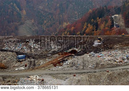 Landfill In The Autumn Time, Trees And Mountains In The Back