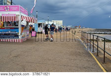Hunstanton, Norfolk, England, Uk - July 25, 2020: People Walking On The Beach On A Cloudy Summer Day