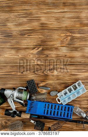 Flat Lay With Fishing Tackle, Fishing Rod And Plastic Box With Fishing Tackle And Hooks, Feeders On 