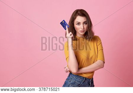Young Asian Woman Holding Credit Card In Casual Yellow Shrit With Denim Jeans.her Facial Reaction Go