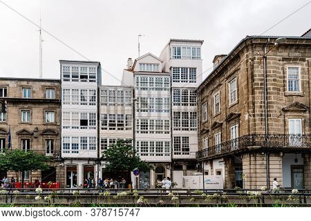 Corunna, Spain - July 20, 2020: View Of Marina Avenue With Unknown People Walking And Houses With Fa