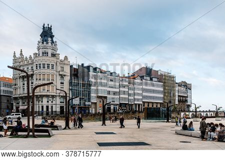Corunna, Spain - July 20, 2020: View Of Marina Avenue With Unknown People Walking And Houses With Fa