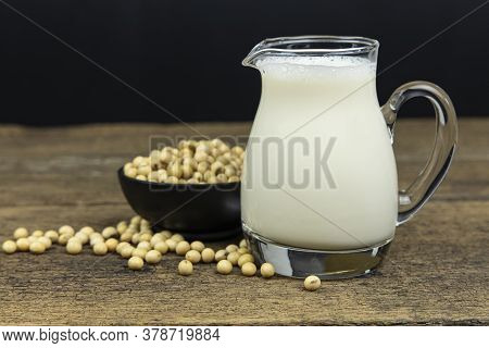 A Glass Of Soymilk With Soybeans On Wooden Table Background.
