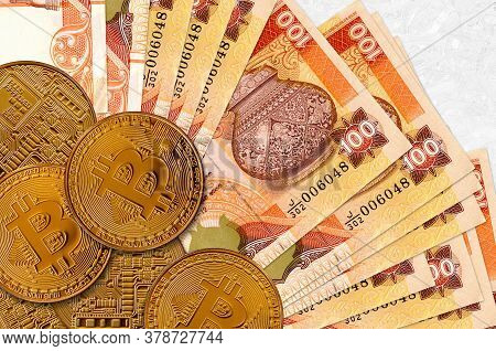100 Sri Lankan Rupees Bills And Golden Bitcoins. Cryptocurrency Investment Concept. Crypto Mining Or