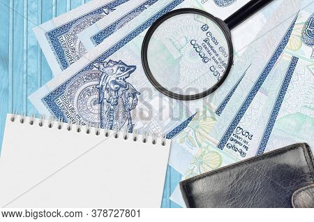 50 Sri Lankan Rupees Bills And Magnifying Glass With Black Purse And Notepad. Concept Of Counterfeit