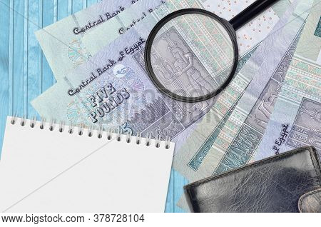 5 Egyptian Pounds Bills And Magnifying Glass With Black Purse And Notepad. Concept Of Counterfeit Mo