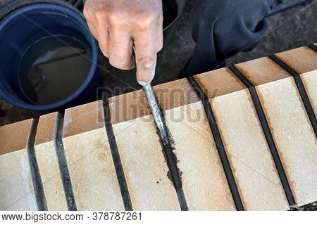 Bricklayer Builds New Fence From Facing Bricks. Alignment Of Inter-brick Joints
