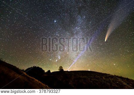 Small Silhouette Of A Scientist With Flashlight On His Head Pointing Bright Beam Of Light On Starry 