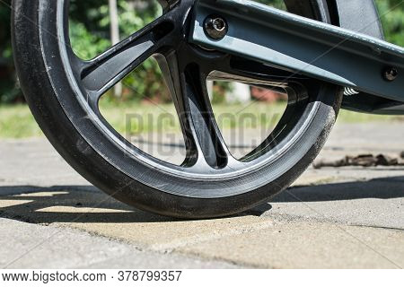 In The Center Of The Photo Part Of The Wheel From A Child's Scooter