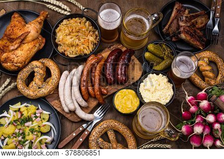 Oktoberfest Dishes: Beer, Pretzel, Sausage, Stewed Cabbage, Potato Salad Half Of Chicken And Ribs
