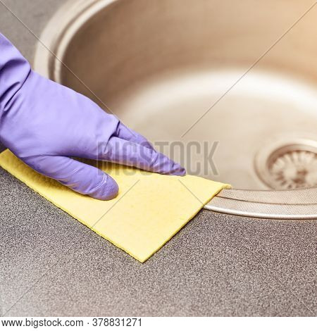 Hand In Protective Glove Clean Kitchen Sink. House Cleaning With Rag. Washing Worktop. Disinfect Ras
