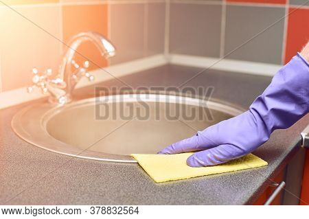 Hand In Protective Glove Clean Kitchen Sink. House Cleaning With Rag. Washing Worktop. Disinfect Ras