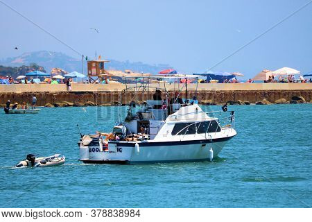 July 30, 2020 In Corona Del Mar, Ca:  Yacht Tugging A Small Craft Out To Sea From The Newport Harbor