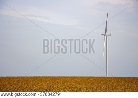Wind Generator Stands In A Field, A Lone Windmill In The Steppe On A Background Of Cloudless No, The