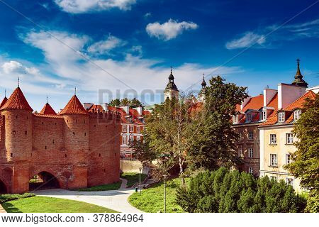 Warsaw, Poland Summer View Of Barbican Or Barbakan Wall And Old Town Houses With Green Trees And Blu