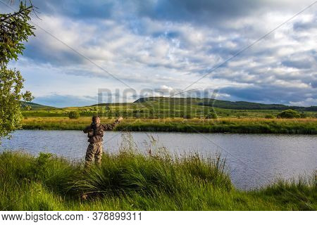 A Fisherman Fly Fishing In The Evening Sun On The Blackwater Of Dee, Galloway, Scotland