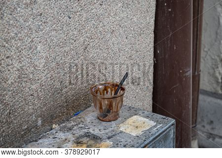 A Plastic Cup And Spoon Left In The Street. Plastic Is Waste Is A Threat To The Oceans And Environme
