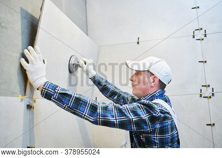 Tiler installing large format tile on wall. home indoors renovation