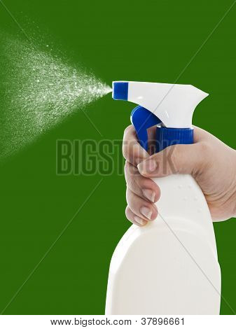 Mano con la limpieza de la botella del aerosol en verde