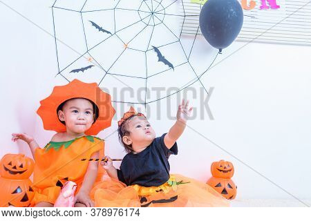 Funny Happy Little Cute Brethren Baby Girl And Kid Boy In Halloween Costume With Orange Pumpkin Jack