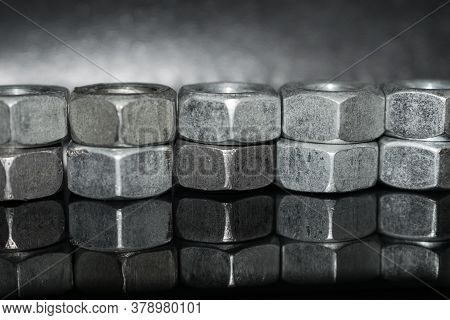 Nuts Stacked In A Row On Top Of Each Other, On A Dark Background And A Reflection At The Bottom