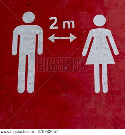 Red Sign On The Floor That Informs People To Keep 2 Meter A Social Distance.the Figures Of A Man And