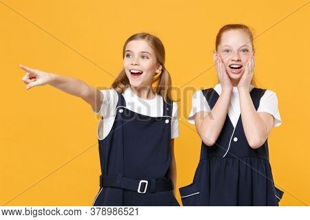 Two Young Little Girls 12-13 Years Old In White T-shirt Blue School Uniform Dresses Isolated On Yell