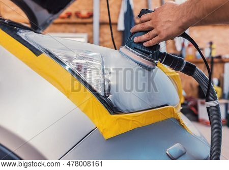 Car Polishing Service - Car Cleaner Specialist Polishing Headlamp With Polish Machine In Workshop Ga