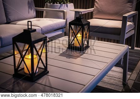 Closeup Of Garden Candles On The Outdoor Table Cozily Illuminating The Patio In The Evening. Backyar