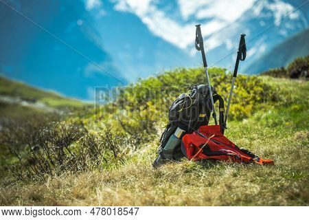 Hikers Backpack, Coat And Trekking Poles  On A Sunny Mountain Trail. Summer Outdoor Activities Theme
