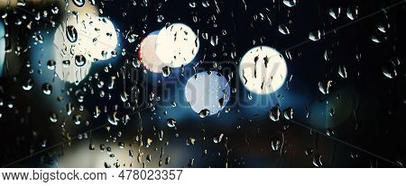 Rain Drop On Window Glass Of Coffee Shop And Blurry City Life Background.