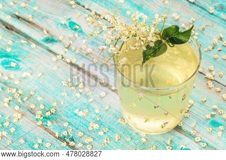Dwarf Elderberry Juice, Elderberry Syrup In A Glass Cup With Blossoms And Bunches Of Elderberries An