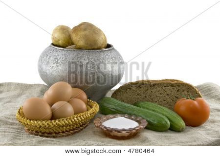 Still-life From Vegetarian Food. Fresh Cucumbers, Eggs Lying In A Wattled Small Basket,