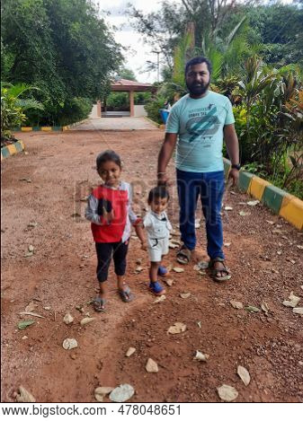 Indian Father With Daughter And Toddler Boy Kid Walking And Sitting In A Machohalli Forest Gate.