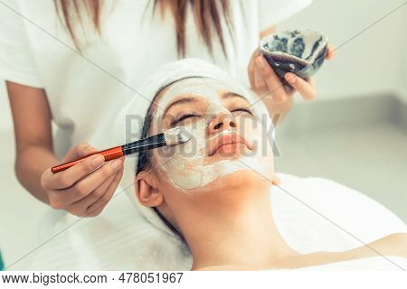 Beautiful Woman Having A Facial Cosmetic Scrub Treatment From Professional Dermatologist At Wellness