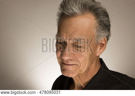 Portrait Of A Mature Man With Graying Hair Wearing A Black Shirt 60plus Looking Down