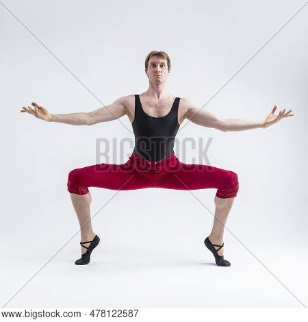 Concentrated Contemporary Ballet Dancer Flexible Athletic Man Posing In Red Tights In Ballanced Danc