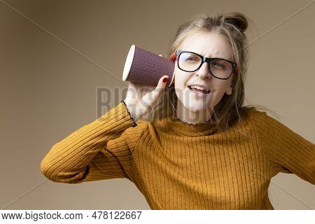 Caucasian Blond Female Girl In Round Glasses Wearing Warm Knitted Sweater Using Disposable Cup For G