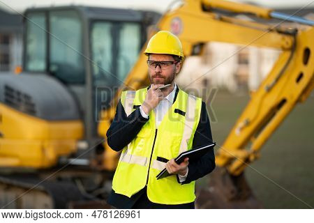 Construction Manager In Suit And Helmet At A Construction Site. Construction Manager Worker Or Super