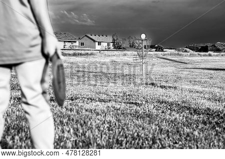 Selective Focus Fairway Grass With A Defocused Young Child Holding A Putter Disc And Golf Goal In Th