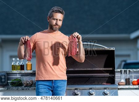 Man Tending To The Grill Cooking Delicious Barbecue Under The Open Sky. Grill Aficionado Barbecue Ex