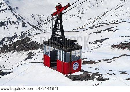 Elbrus, Russia - June 08, 2023: Empty Cabin Of The Old Cable Car Against The Backdrop Of Eternal Sno