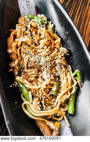 Asian Noodles With Sesame And Teriyaki In A Plate Close-up.