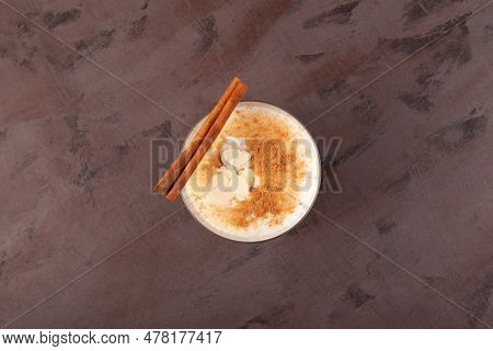 Salep Or Sahlep In Cup On Textured Brown Surface, Top View. Turkish Hot Drink With Cinnamon And Spic