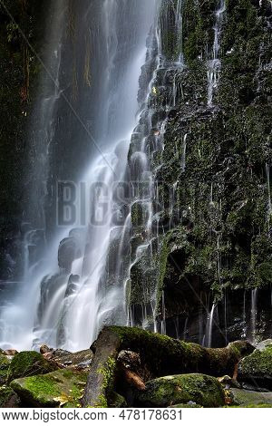 Waterfall Coming Down On The Rocks In New Zealand