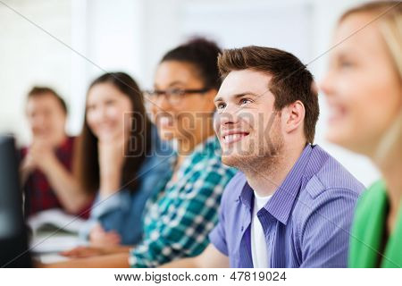 education concept - students with computers studying at school
