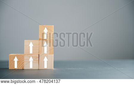 Wooden Blocks With Target Icon On Top, Surrounded By Rise Up Arrows. Bar Graph Chart Steps On Blue B