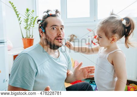 A Bearded Dad Being Silly And Playful With His Daughter While Putting On Makeup, Creating Funny And 