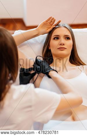 Doctor Is Doing Electroepilation To The Client, Using Electro Needle And Tweezers. Hair Removal Proc